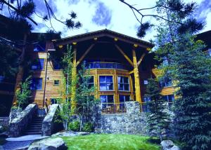 Cette grande maison en rondins possède une grande fenêtre. dans l'établissement Teton Club, à Teton Village