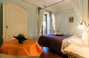 1 dormitorio con cama, mesa y ventana en B&B 8380 Saturnia Terme en Saturnia