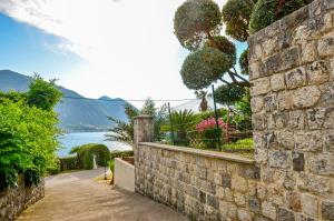 a stone wall with a walkway next to a body of water at La Grande Apartments in Kotor