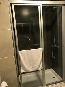 a shower with a glass door with a towel at Hotel Luz y Fuerza San Bernardo - All Inclusive in San Bernardo