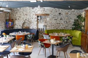 un restaurant avec des tables, des chaises et un canapé vert dans l'établissement Logis Hotels Le Champalud Restaurant La Citadelle, à Champtoceaux