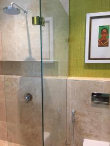 um chuveiro com uma porta de vidro na casa de banho em Nakai Beach Homestay em Trafalgar