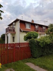 une maison avec une clôture rouge devant elle dans l'établissement Florianus Vendeghaz, à Berekfürdő