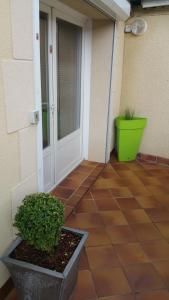 un patio con una porta bianca e una pianta verde di Le Cocoon De Sacha a Avize