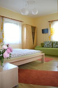 a bedroom with a bed and a green couch at Florianus Vendeghaz in Berekfürdő