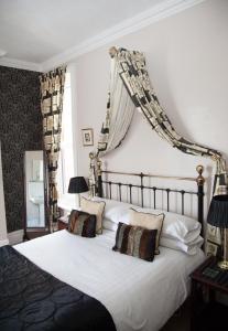 a bedroom with a large white bed with pillows at The Langtons Bed & Breakfast in Eastbourne