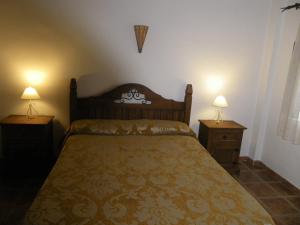 Un dormitorio con una cama y dos mesitas de noche con lámparas. en Caballero de Castilla, en Santiuste de San Juan Bautista
