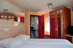 - une chambre avec un lit blanc et une salle de bains dans l'établissement Hotel Les Arcades, à La-Roche-en-Ardenne