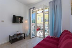 a living room with a couch and a sliding glass door at Apartments Aquamarine in Funtana