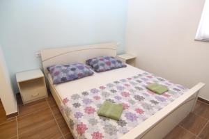 a bedroom with a bed with two pillows on it at Amazing sea view apartments Ljubic in Pag