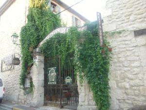 un edificio de piedra con una puerta con hiedra. en Appartement Le Romarin, en Mallemort