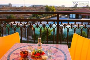a table with a bottle of wine and a bowl of fruit at Monachus Monachus in Frangokastello
