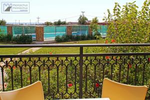 a balcony with two chairs and a garden at Monachus Monachus in Frangokastello