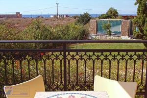 a balcony with a table and chairs on a fence at Monachus Monachus in Frangokastello