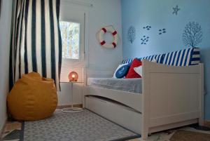 a childs bedroom with a bed and a window at Sargantana Blava in Sant Carles de la Ràpita