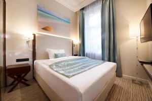ein Schlafzimmer mit einem großen weißen Bett und einem Fenster in der Unterkunft Boutique Hotel Adria in Wels