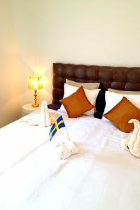 a large white bed with stuffed animals on it at Brodderud Apartments in Mariestad
