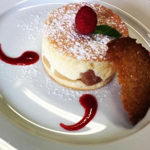 une assiette blanche avec un gâteau recouvert d'une framboise dans l'établissement Kyriad Auray, à Auray