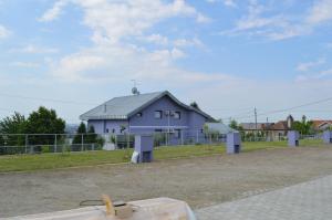 een blauw huis met een hek ervoor bij Pansion Antonio in Slavonski Brod