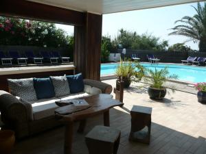 a patio with a couch and a table and a pool at Levolle Marine in Poggio-Mezzana
