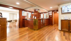an office with wooden floors and a bar in the middle at México PR in Santiago de Compostela