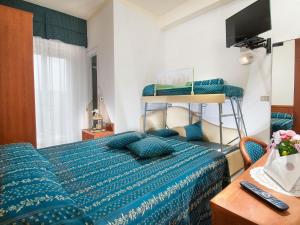 a bedroom with a bed with a blue comforter at Hotel caesar in Cattolica