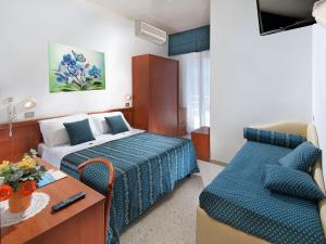 カットーリカにあるHotel Caesarのベッドとソファ付きのホテルルーム