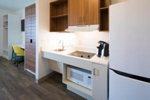 a kitchen with a sink and a microwave at Uptown Suites Extended Stay Charlotte NC - Concord in Concord