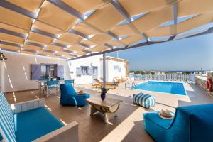 a living room with blue furniture and a swimming pool at Crystal Villa I in Chrissi Akti