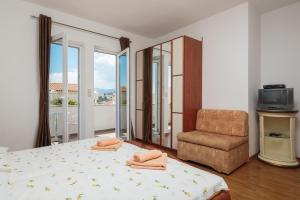 a bedroom with a bed and a chair and a window at House Coko in Baška Voda