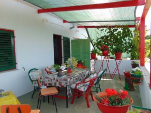 un patio con mesa, sillas y plantas en Apartment Fana en Grohote