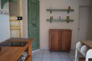 オーバーニュにあるAppartement en Provenceのキッチン(緑のドア、壁に棚付)