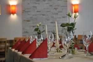a table with wine glasses and red napkins on it at Landgasthof Linkenmühle in Hornbach