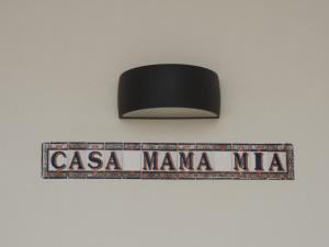 Um sinal que diz "casa mama mma" pendurado numa parede em Casa Mama Mia em Moncarapacho