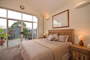 a bedroom with a large bed and a large window at Captains at the Bay in Apollo Bay