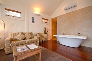 a living room with a couch and a bath tub at Captain's at the Bay in Apollo Bay