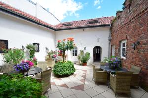 un patio esterno con tavoli, sedie e fiori di Ferienhaus Burgblick Brueggen a Brüggen