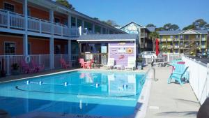 a swimming pool in front of a hotel at Pirates Cove in Carolina Beach