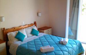 Un dormitorio con una cama azul con toallas. en Gorgona apartments & studios, en Ýpsos