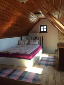 Cama en habitación con techo de madera en Vörösmál Vendégház, en Balatonfüred