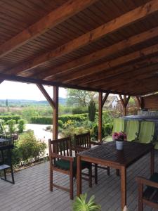 a wooden table and chairs on a patio with a roof at Vörösmál Vendégház in Balatonfüred
