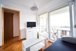 a living room with a couch and a large window at Apartments Dream in Nin