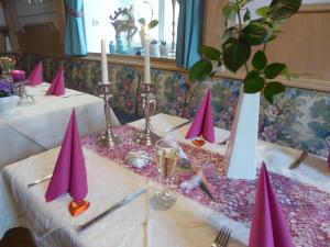 uma mesa com guardanapos cor-de-rosa e velas em Hotel zur Post em Lam