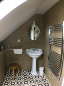 baño con lavabo, espejo y taburete en les jardins de la Matz, en Plouër-sur-Rance