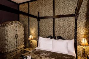 1 dormitorio con cama con dosel y almohadas blancas en Old City House Inn and Restaurant en Saint Augustine