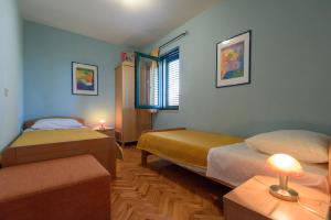 a bedroom with two beds and a table with a lamp at Villa Lily Comfortable holiday residence in Veli Iž +37 photos