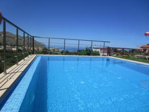 uma grande piscina com vista para o oceano em Villa Amfimala em Georgioupolis