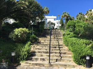 um conjunto de escadas de pedra com palmeiras e arbustos em Estepona Golf - Los Pintores em Estepona