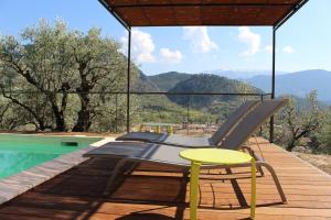 a deck with a chair and a table and a pool at Villa Pialats in Buis-les-Baronnies
