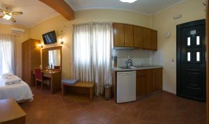 a room with a kitchen and a bedroom with a bed at Petros Penthouse in Parga